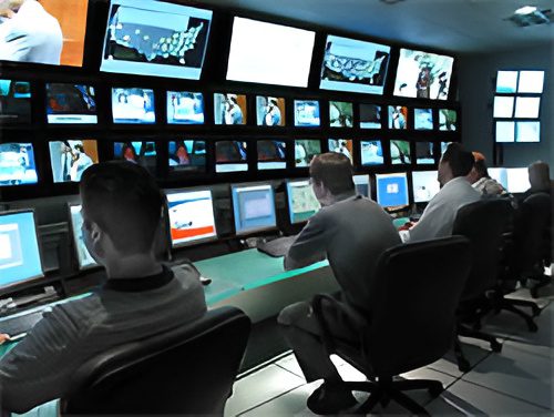 People monitoring screens in a control room.